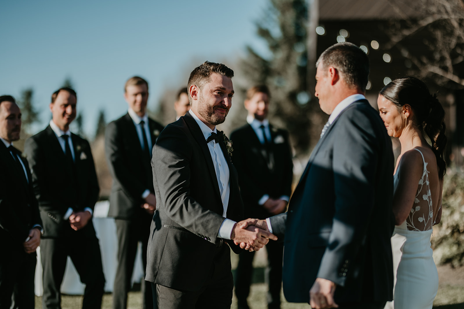 Groom shaking brides dads hand at Calgary Pinebrook Golf Club wedding ceremony