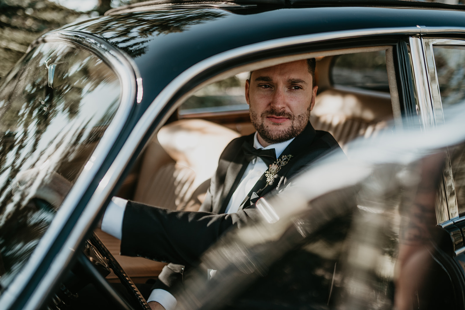 groom through the window of a vintage Jaguar 