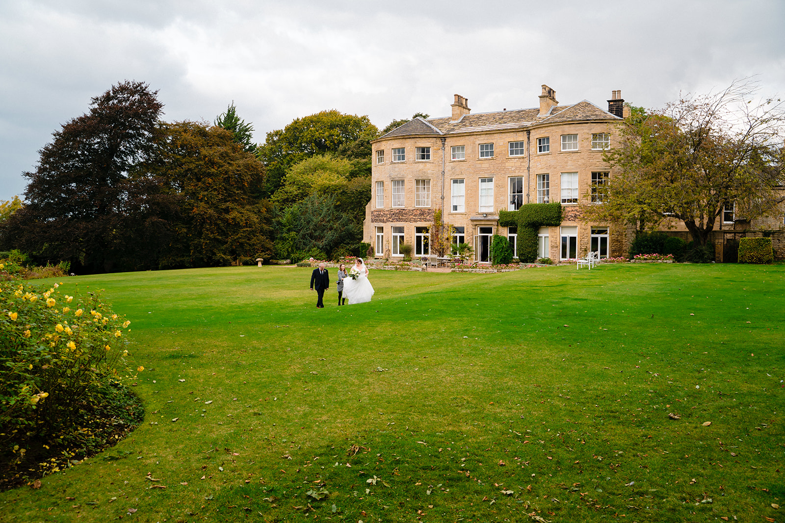 bride walks across grass at Hooton Pagnell Hall