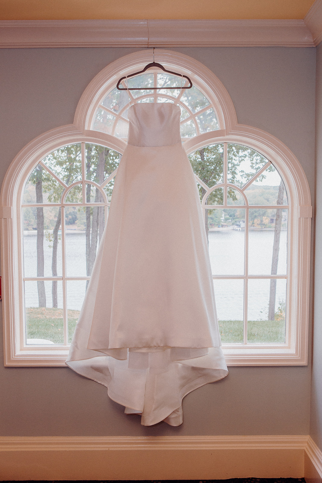 A bridal gown hanging in the window