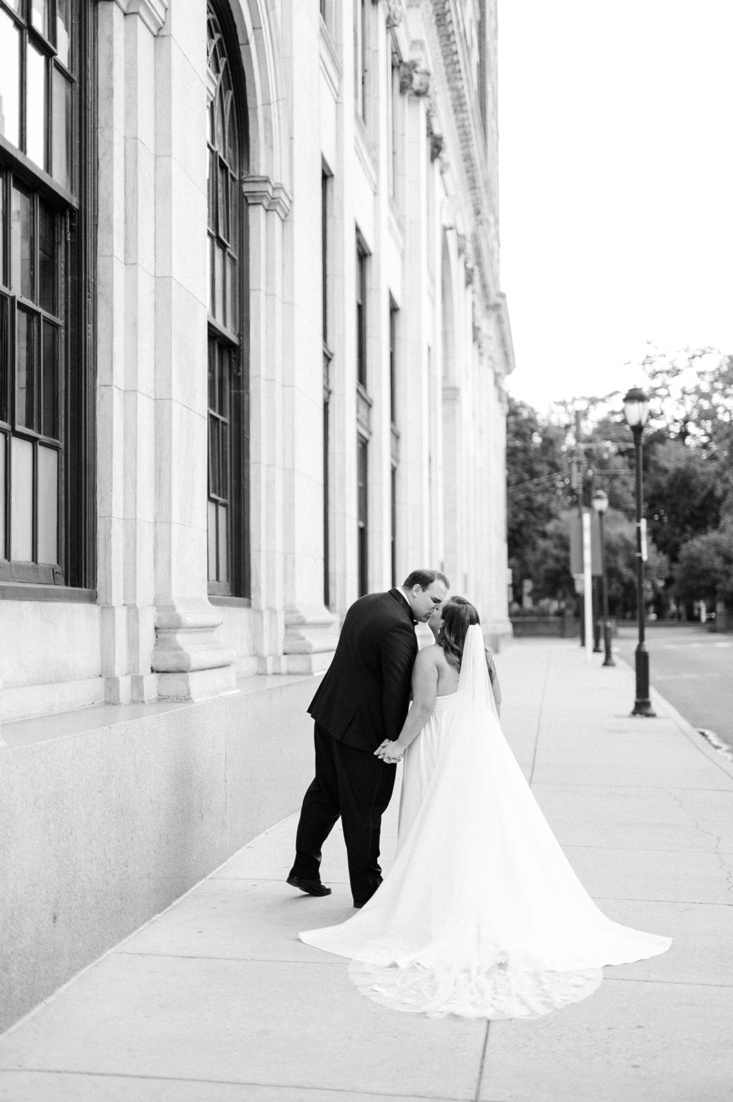 black and white photo of bride and groom kissing on the street Classic AutumnWedding at Philadelphia’s Union Trust