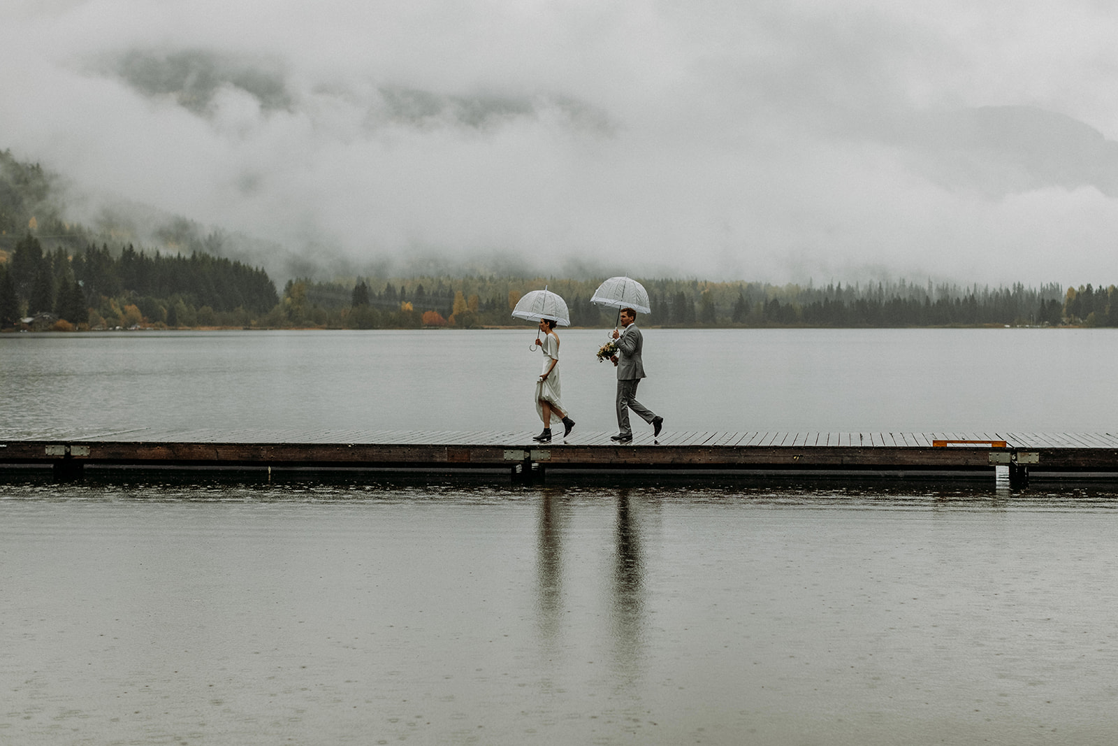 bride and groom walking out onto a dock in Whistler
