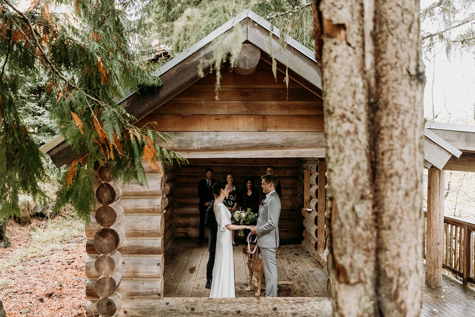 Bride and groom sharing vows in a tiny log cabin in whistler