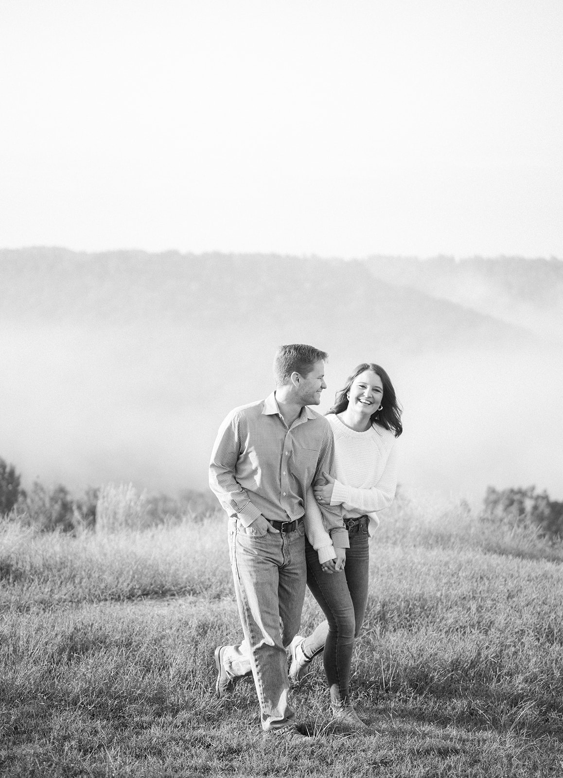 An engaged couple poses on the foggy bluff at Weathington Park, in Section, Alabama in black and white