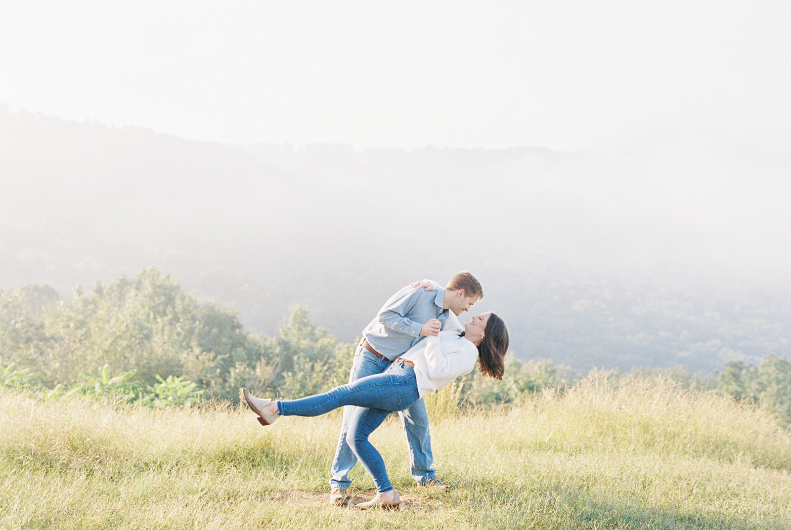 An engaged couple poses on the foggy bluff at Weathington Park, in Section, Alabama
