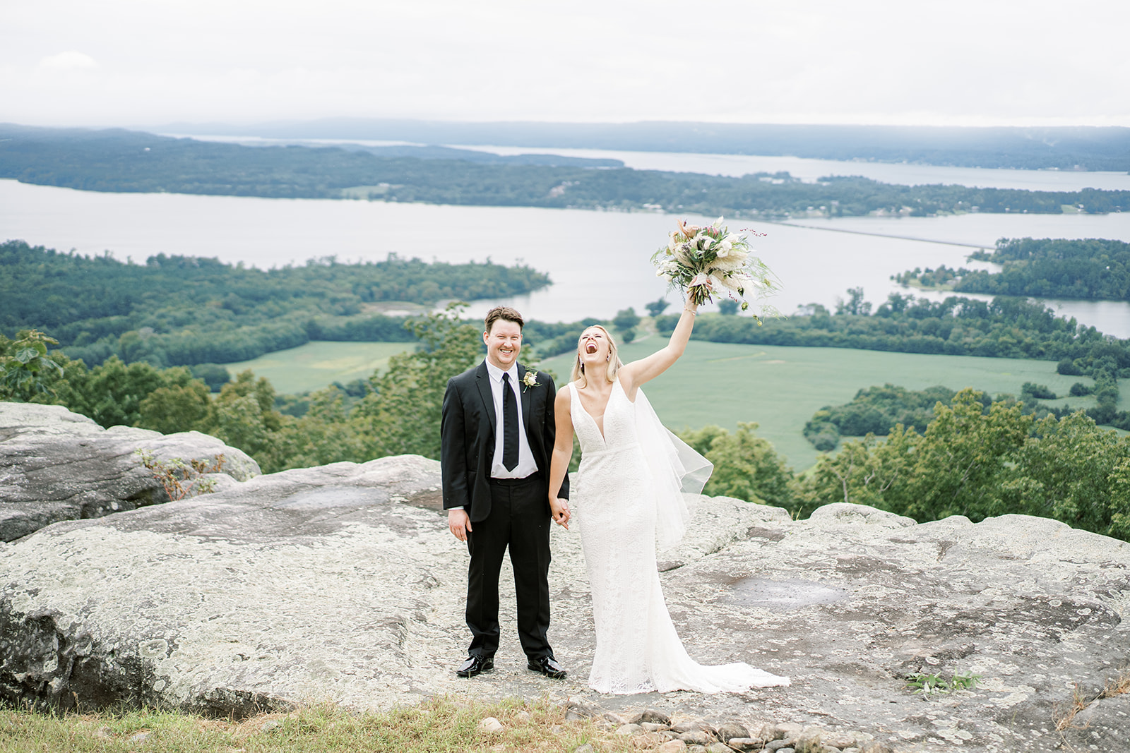 The bride and groom laugh with excitement on the bluff of Infinity Event Venue