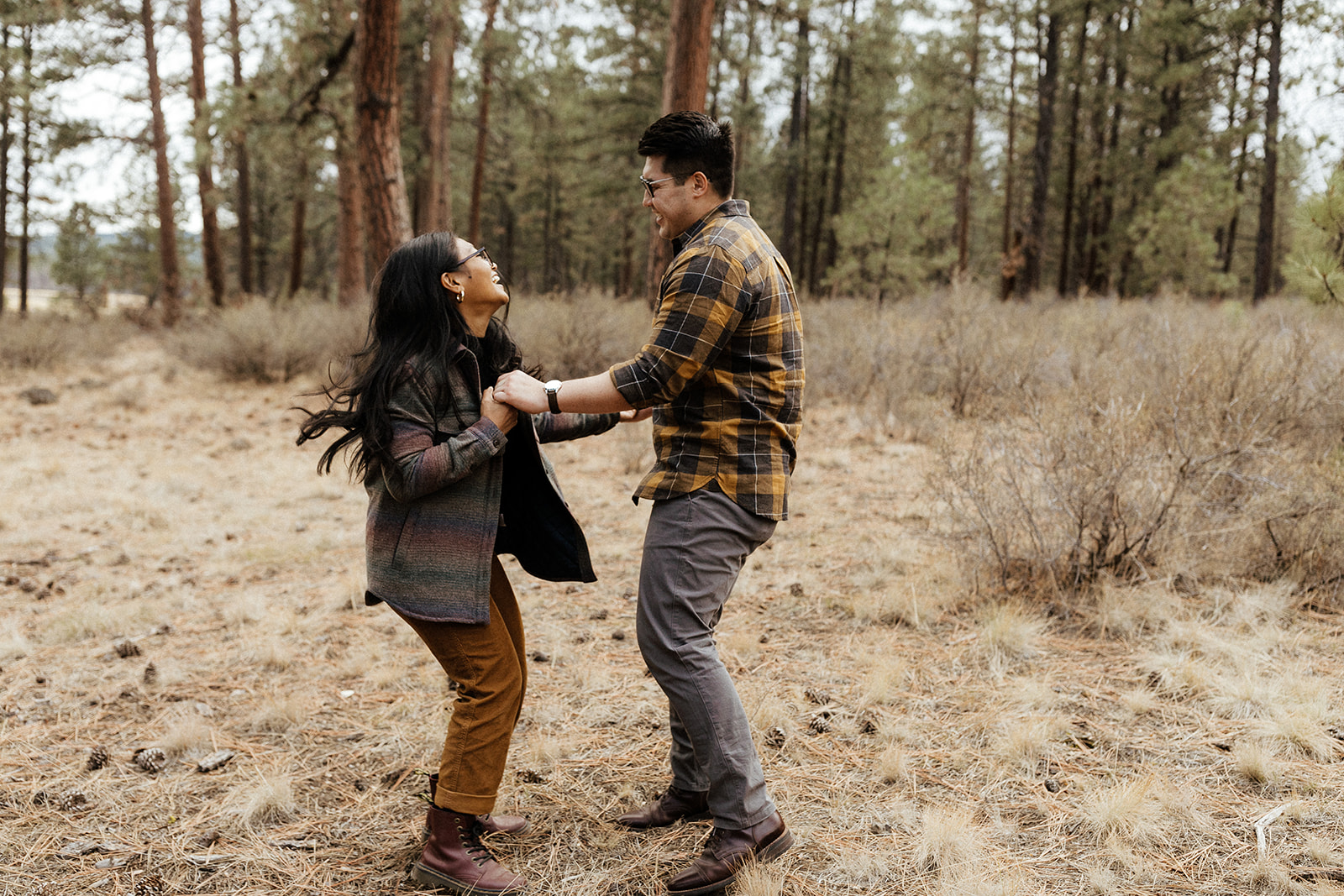 couple dancing and holding hands in the forest at Dillon Falls.