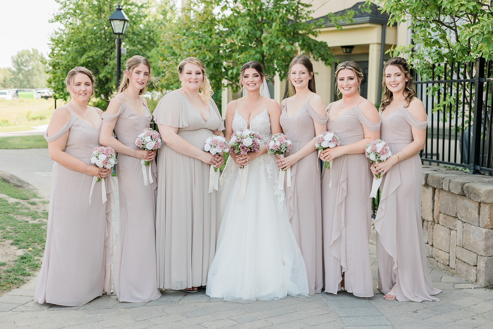 Bride and bridesmaids all lined up in a row with bouquets