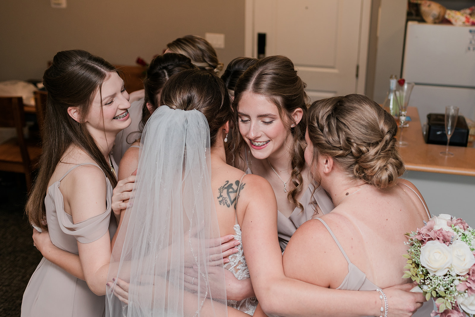 bride and bridesmaids doing a group hug