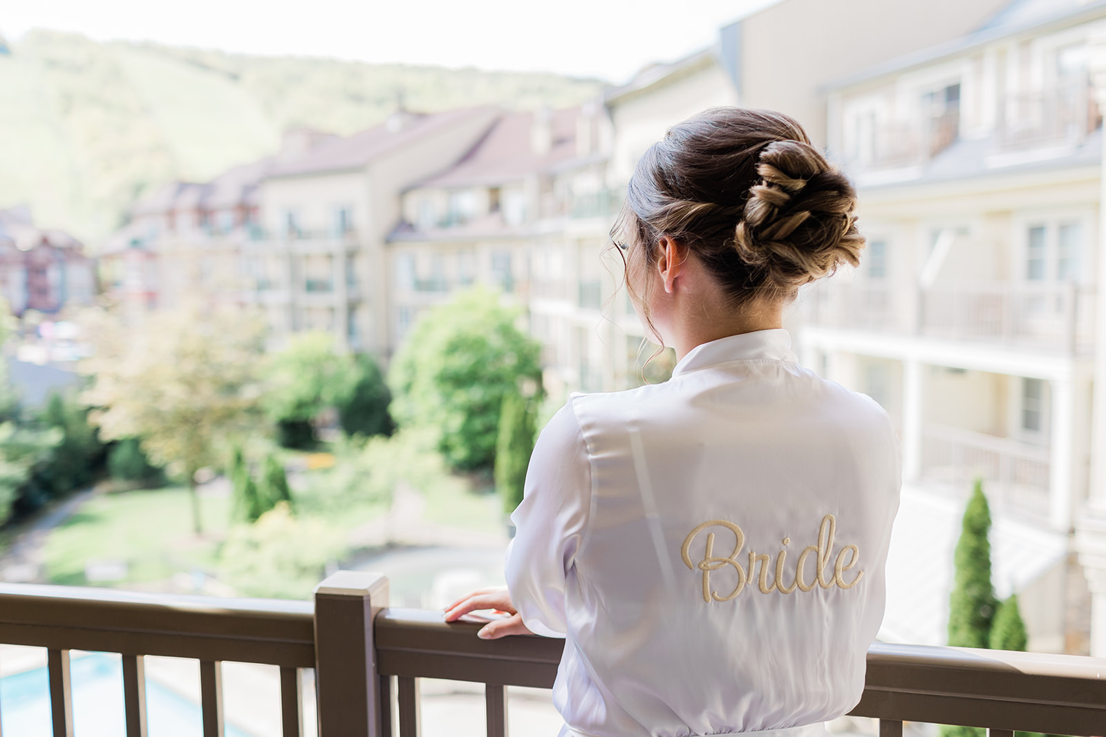 bride on balcony overlooking blue mountain resort in silk robe