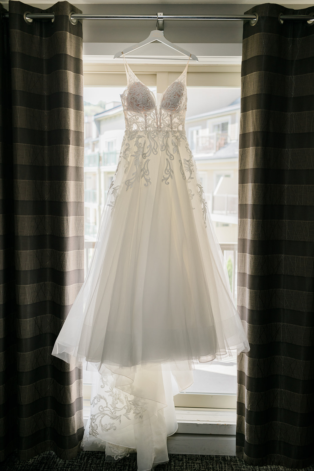 brides dress hanging in windor