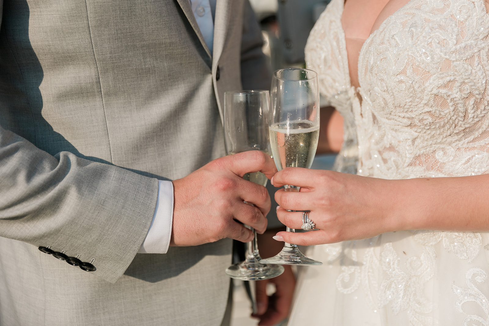 close up of bride and groom holding champagne glasses