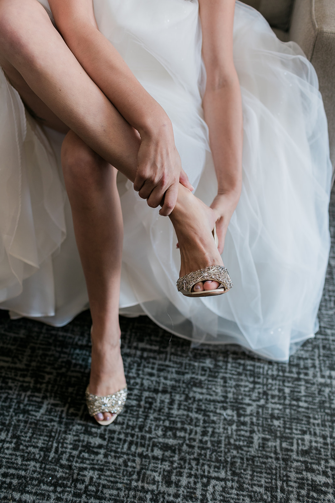 close up of bride putting on her wedding shoes