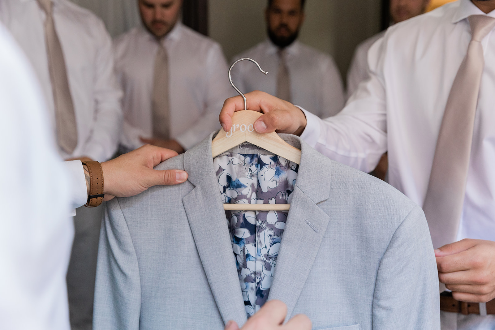getting the jacket ready to put on the groom