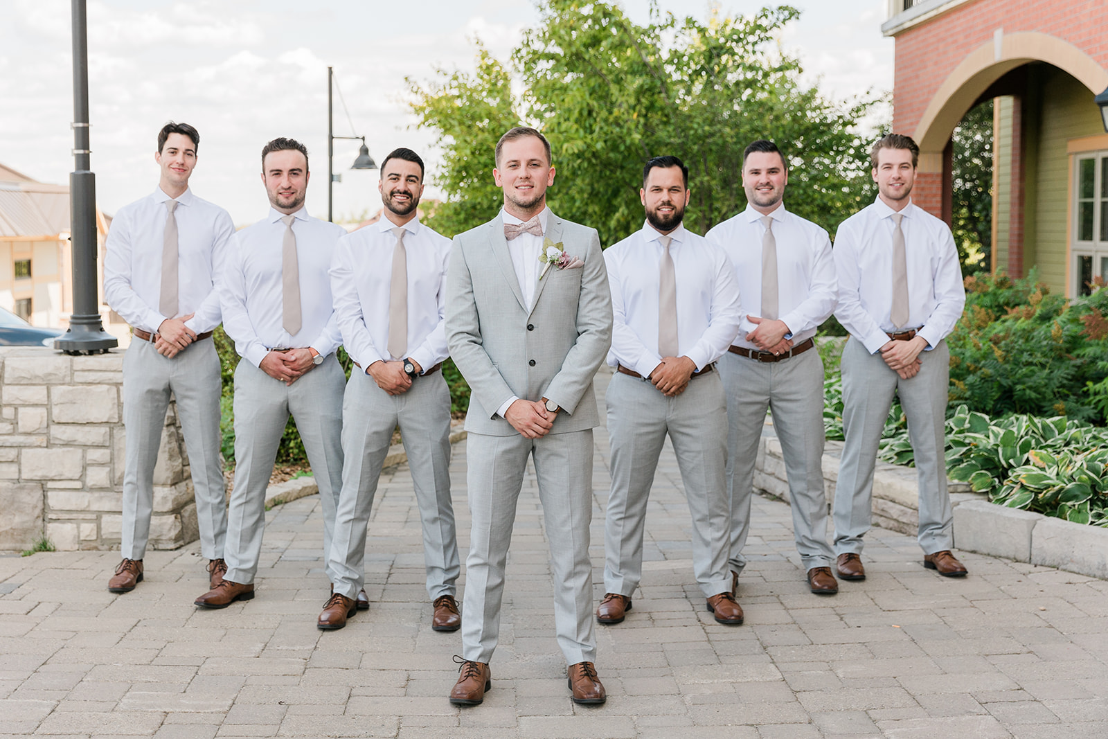 Groom and groomsman standing in a line in a V formation