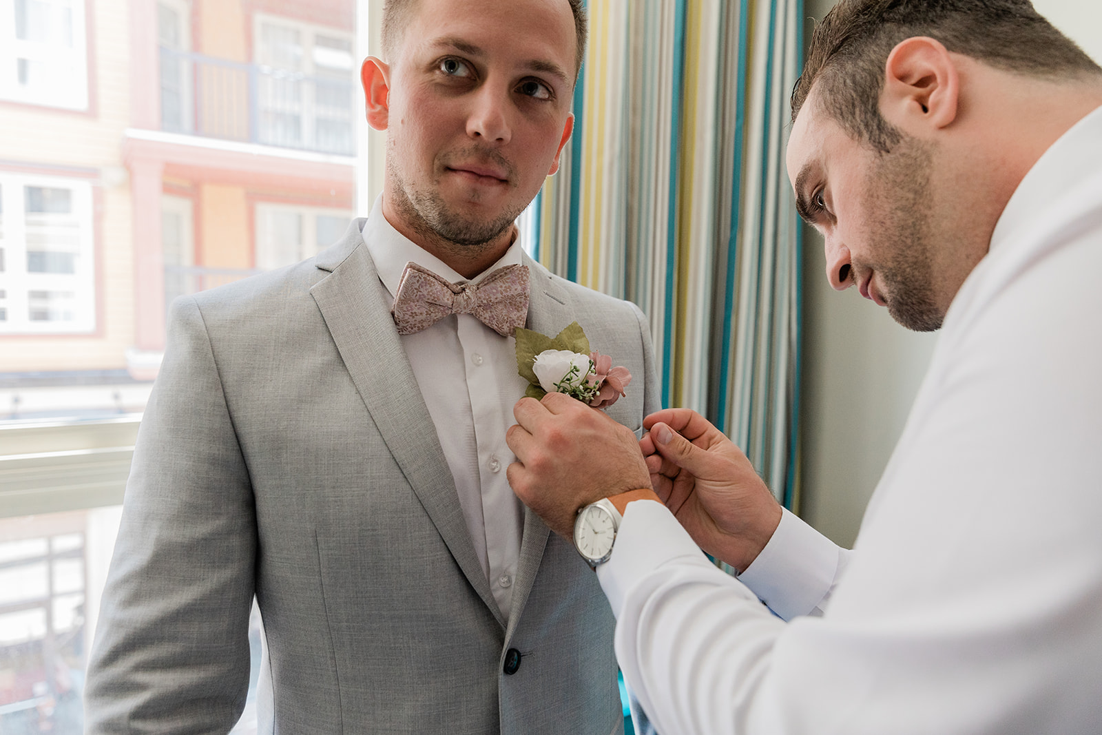 groomsmen putting on the grooms boutonnière 