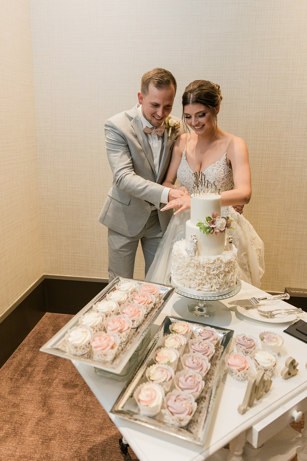 wide shot of couple smiling and cutting cake