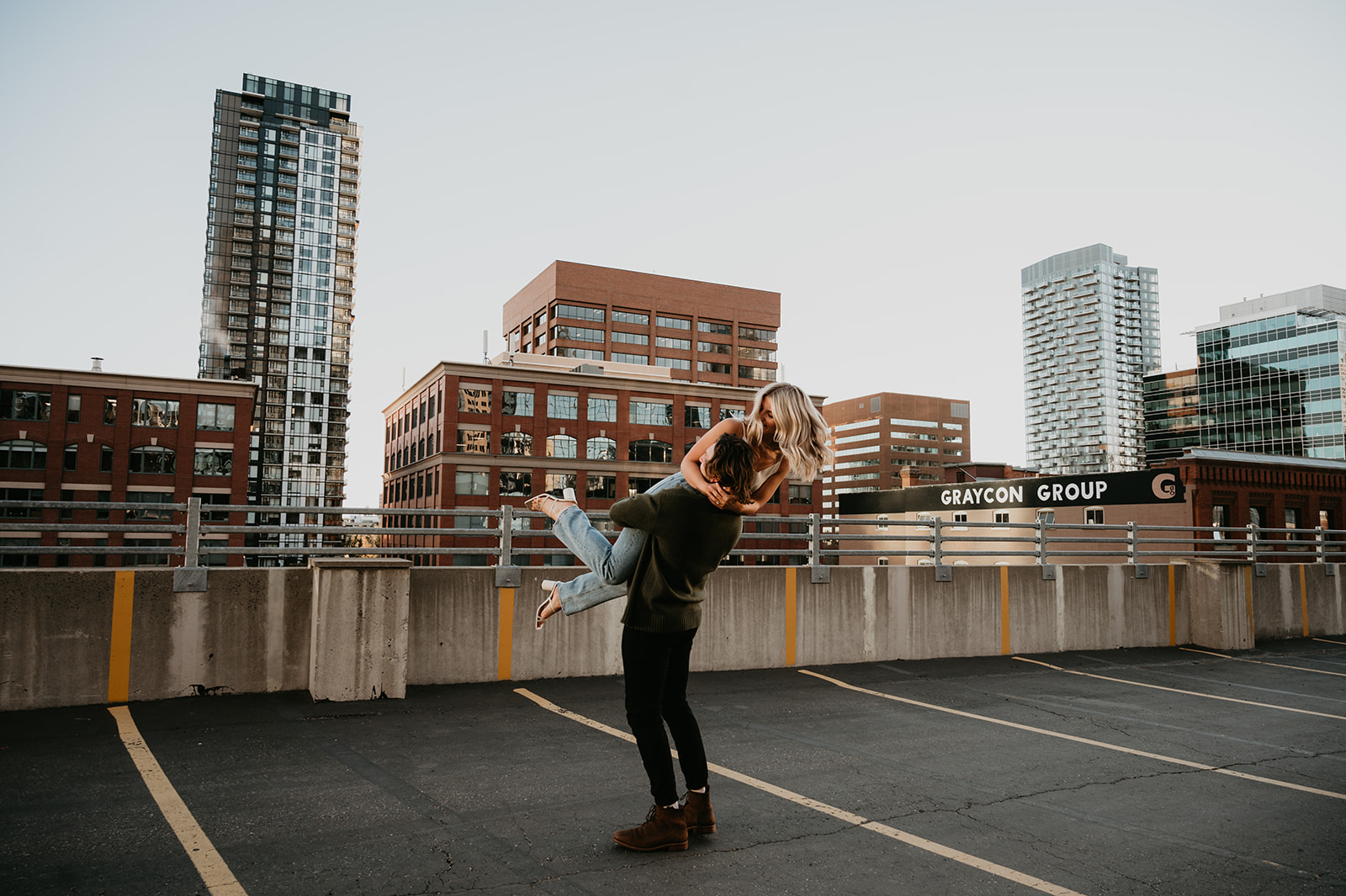 Urban stylish couple on a rooftop parking garage in Calgary Alberta for their engagement session