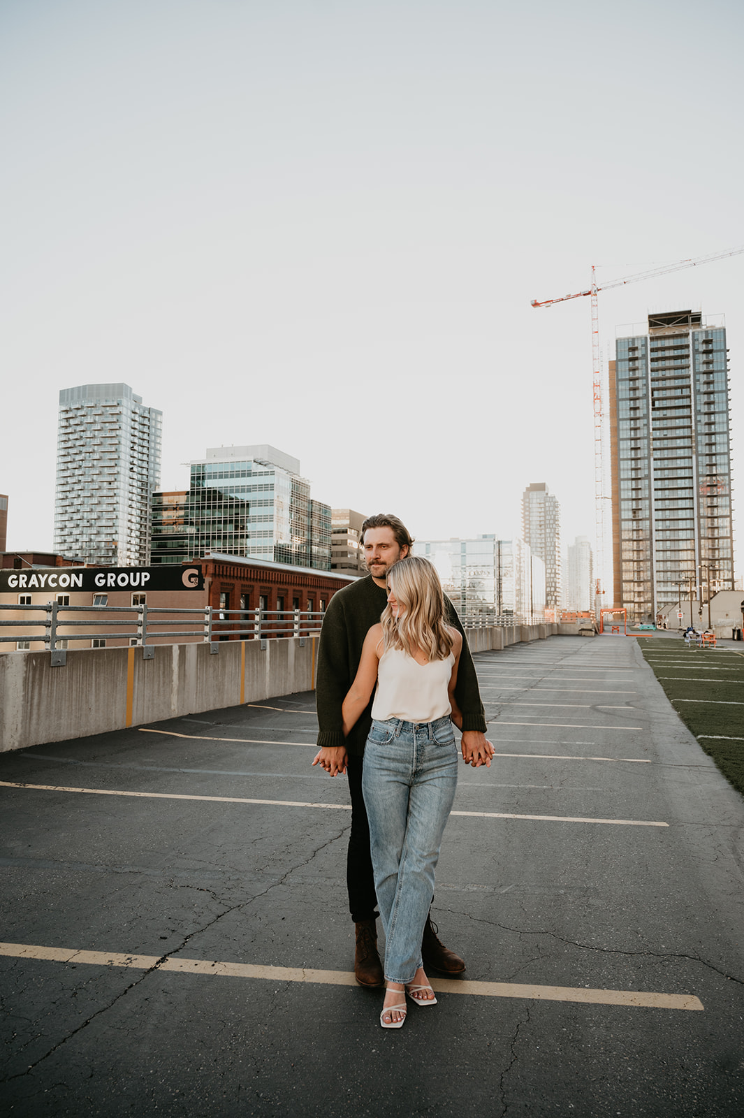 Urban stylish couple on a rooftop parking garage in Calgary Alberta for their engagement session