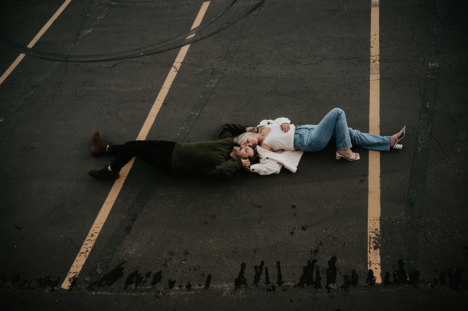Couple laying down during their engagement photos at an Urban Parking garage in Calgary Alberta