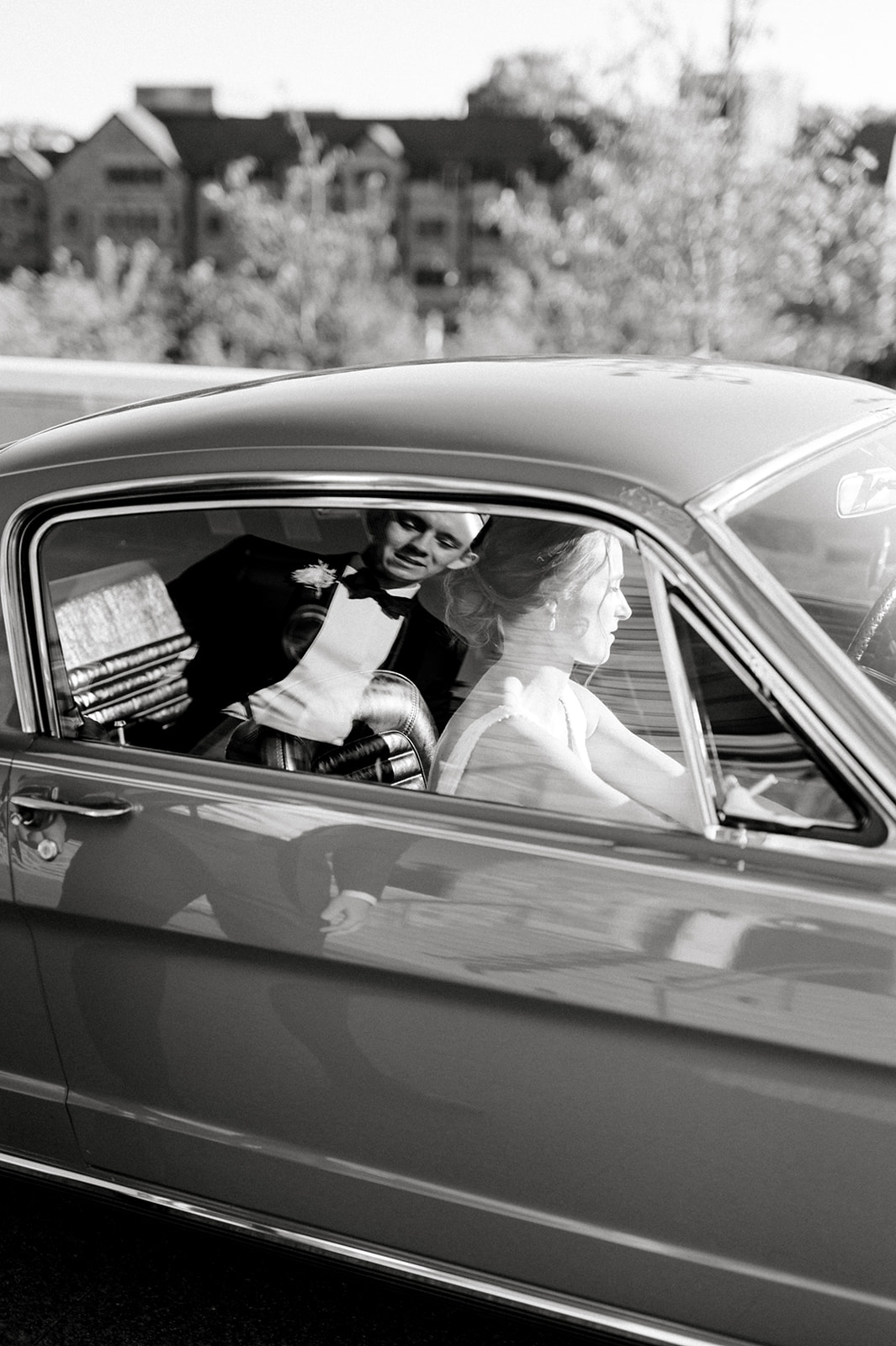 black and white photo of bride and groom reflection on classic red mustang at Union League of Philadelphia wedding