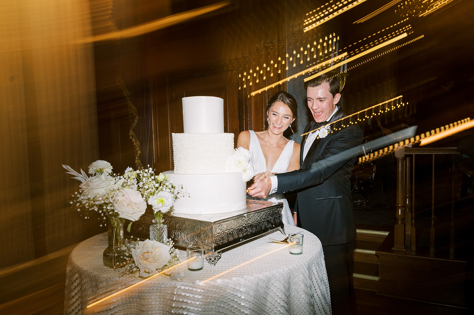 bride and groom cut the cake at modern classic black and white union league of philadelphia wedding