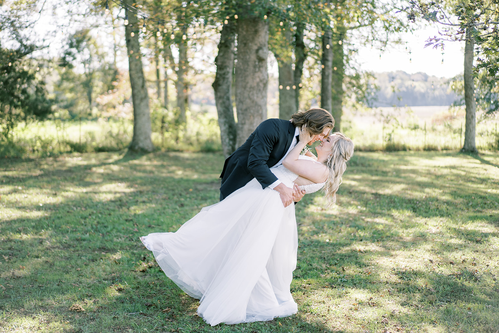 The bride and groom dip for a kiss at Harvest Hollow at their fall wedding