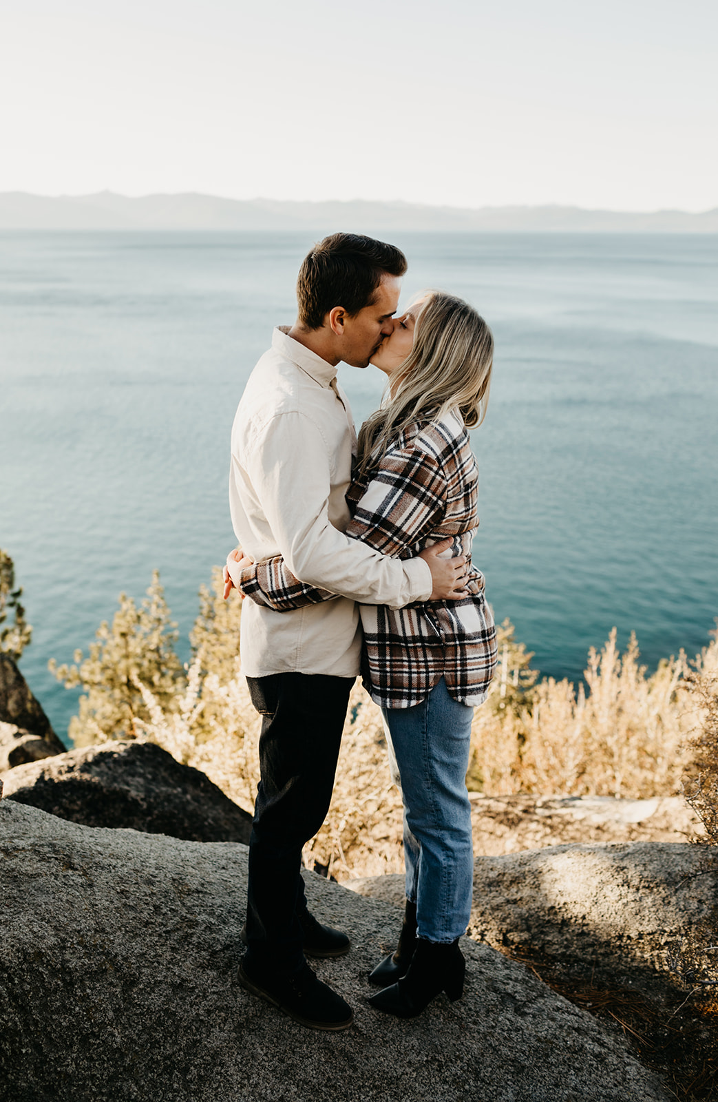 Couple kisses with a view of lake tahoe in the background