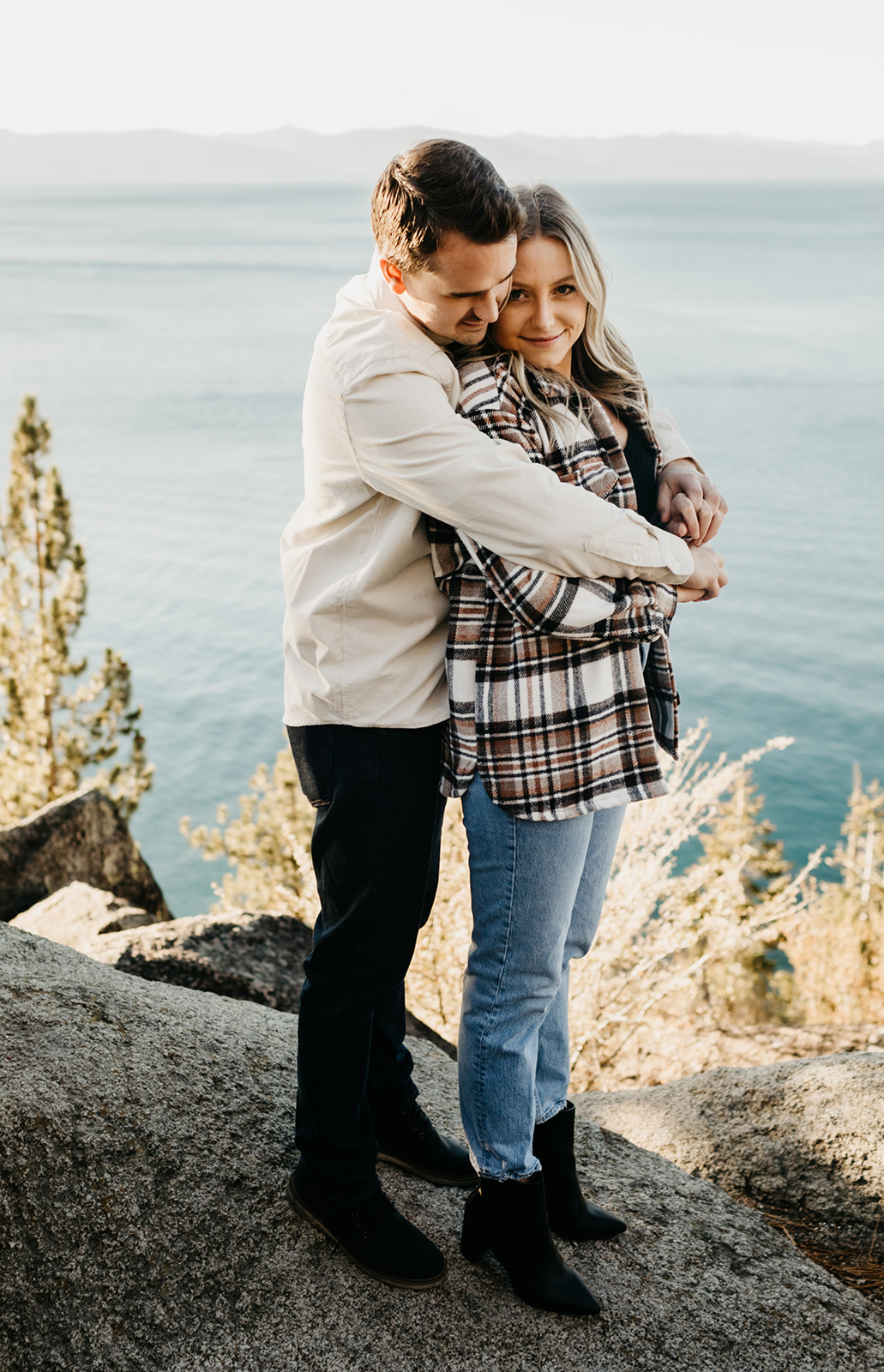 Couple wraps up together with a view of lake tahoe in the background