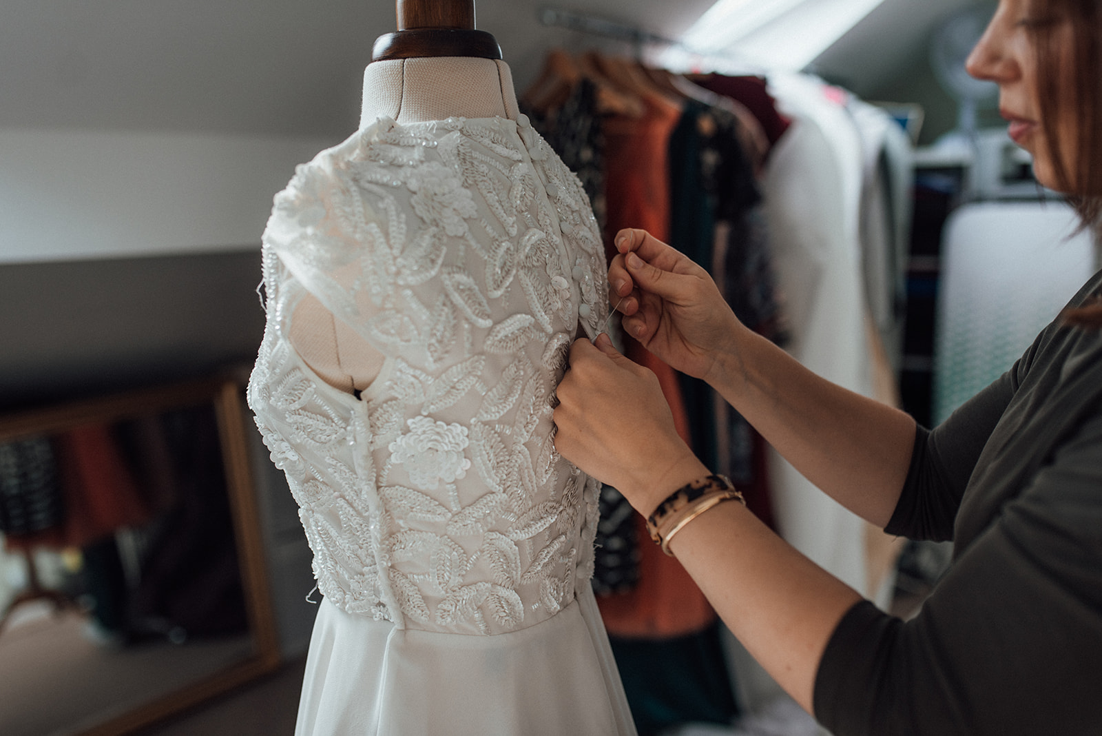 close up of a seamstress making alterations on a bridal gown
