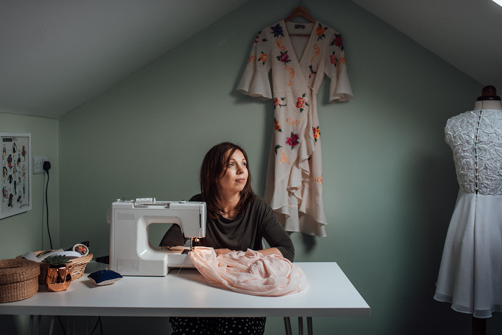 A seamstress in her home studio, making alterations at her sewing machine