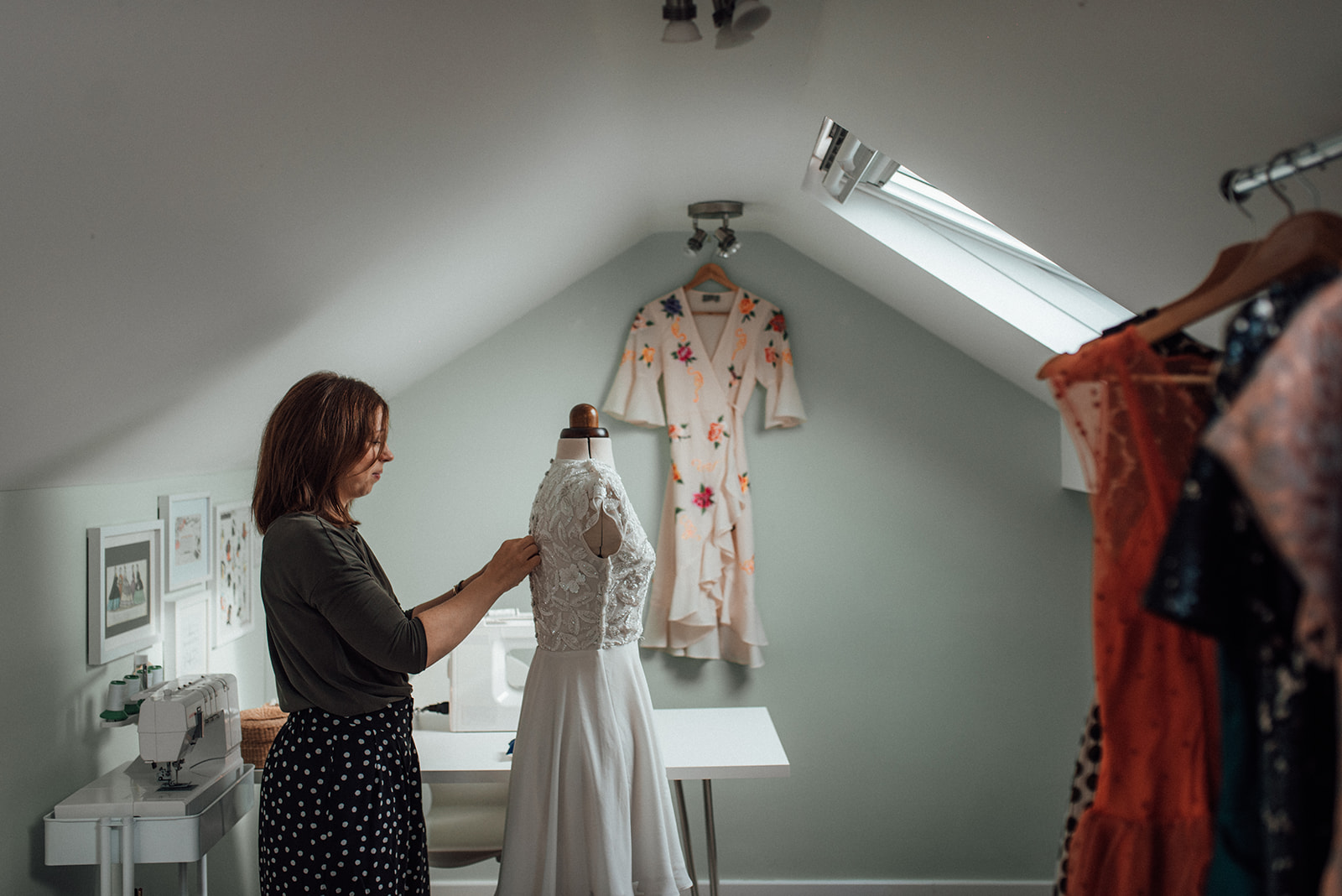 a seamstress in her home studio pinning a dress to make alterations
