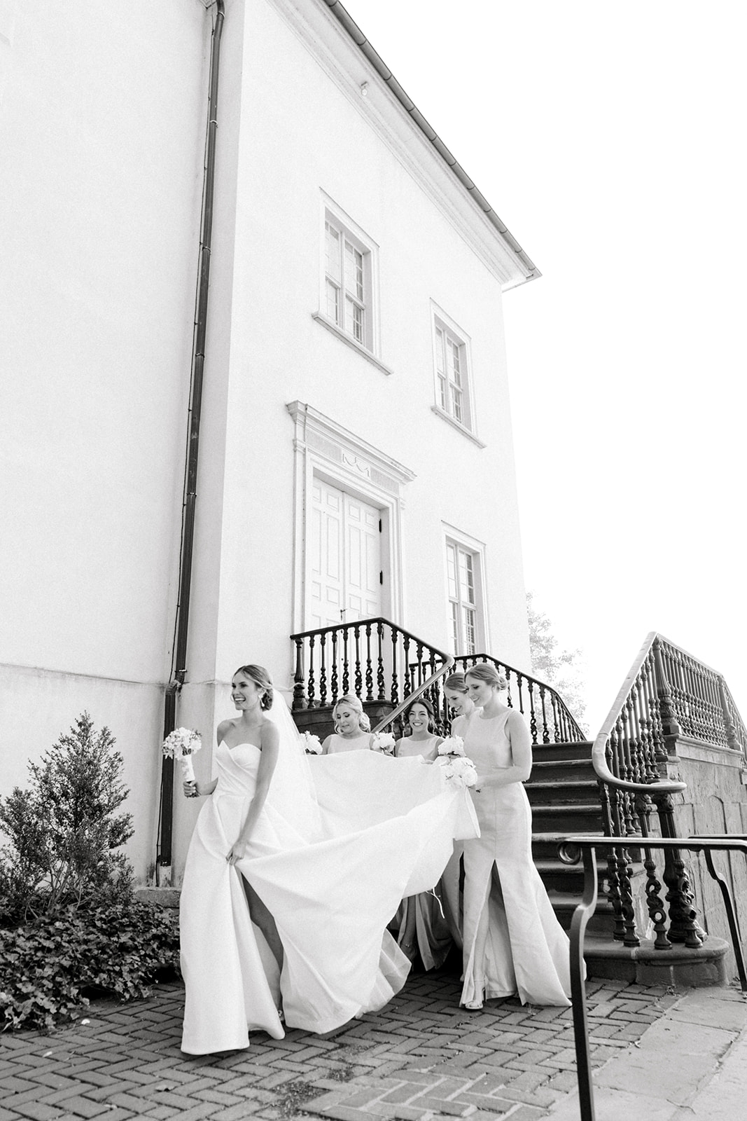 black and white photo of bridesmaids walking outside bethlehem church