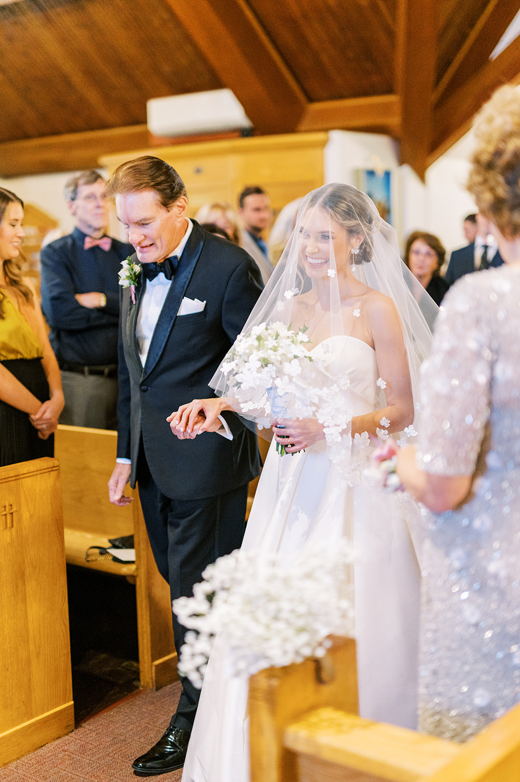 bride walks down church aisle with her father