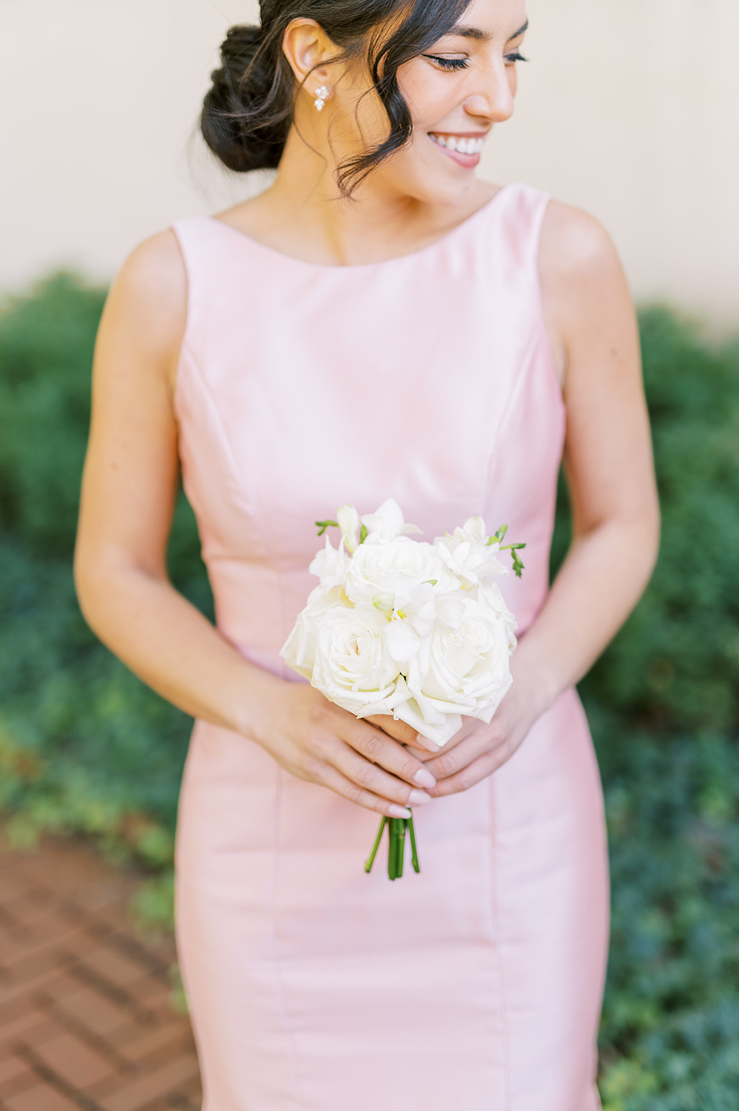 bridesmaid in pink satin dress with simple white bouquet