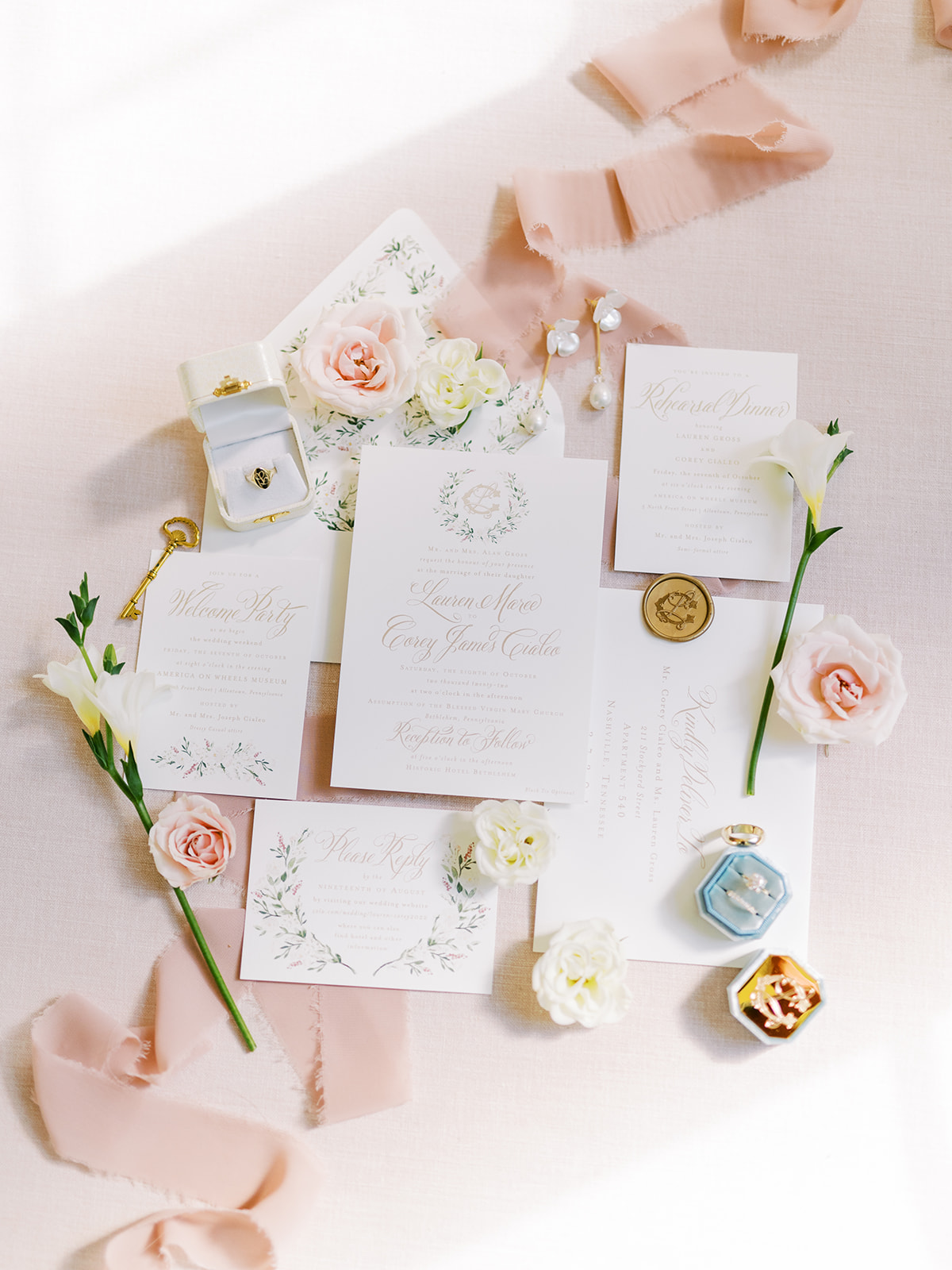 invitation suite laid on pink linen with flowers