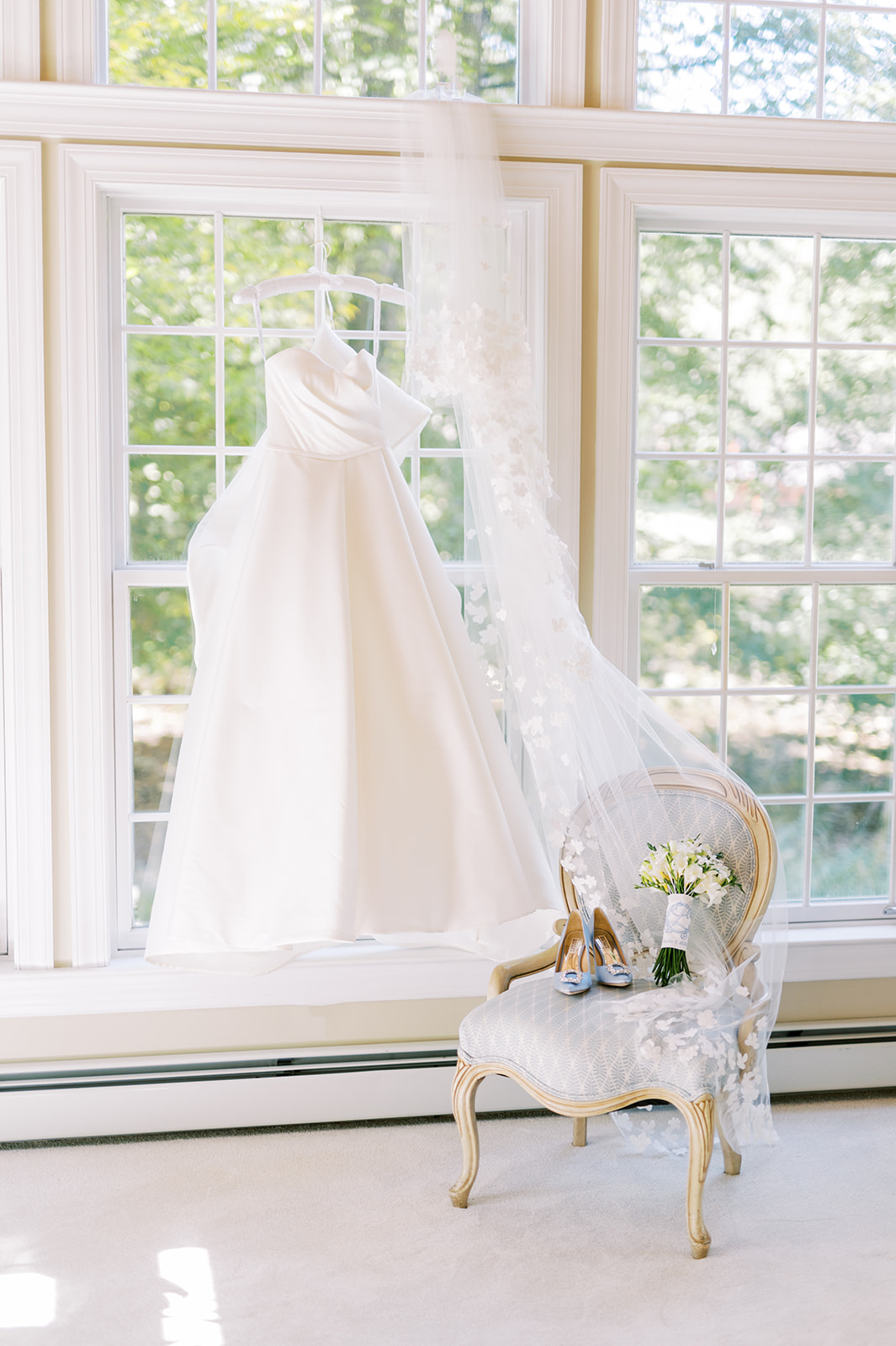 wedding gown hanging from wall of windows
