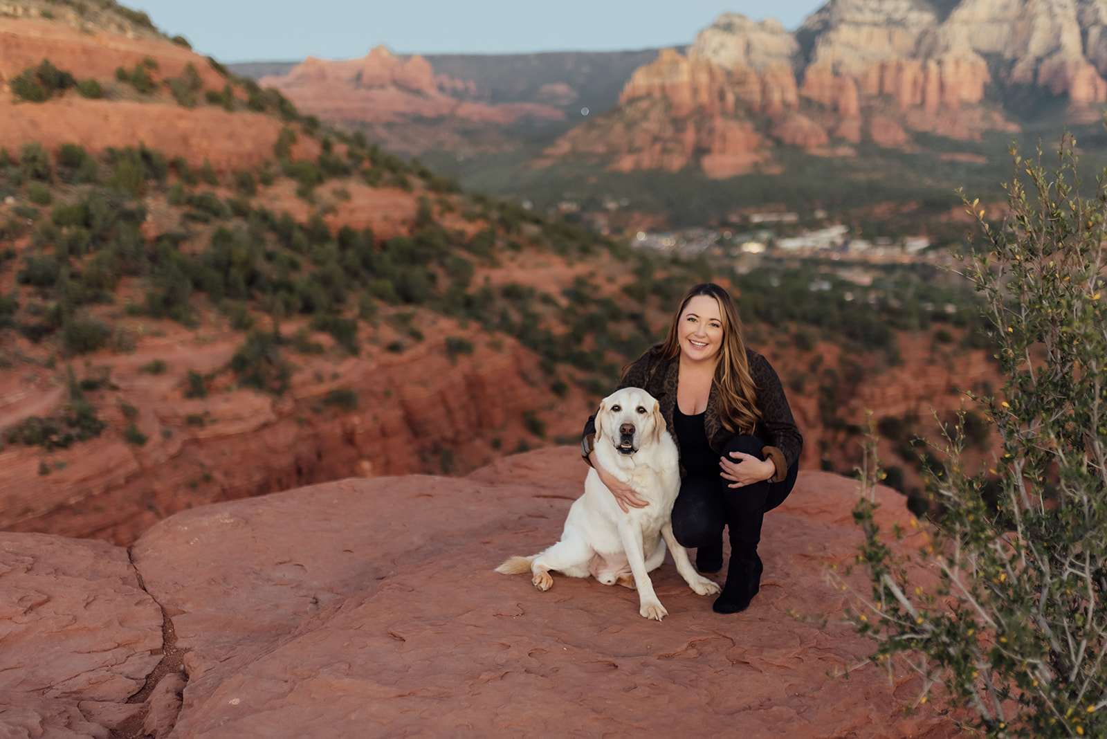 woman with dog and Sedona red rocks behind