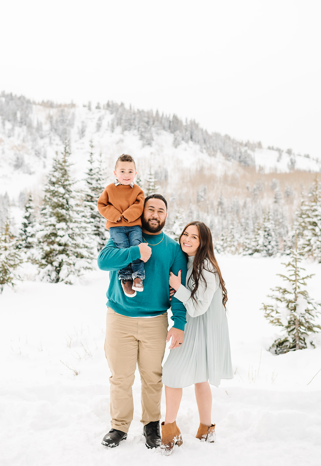 Small family in jewel tone colors pose at snowy Silver Lake up Big Cottonwood Canyon in Utah Family Photograph