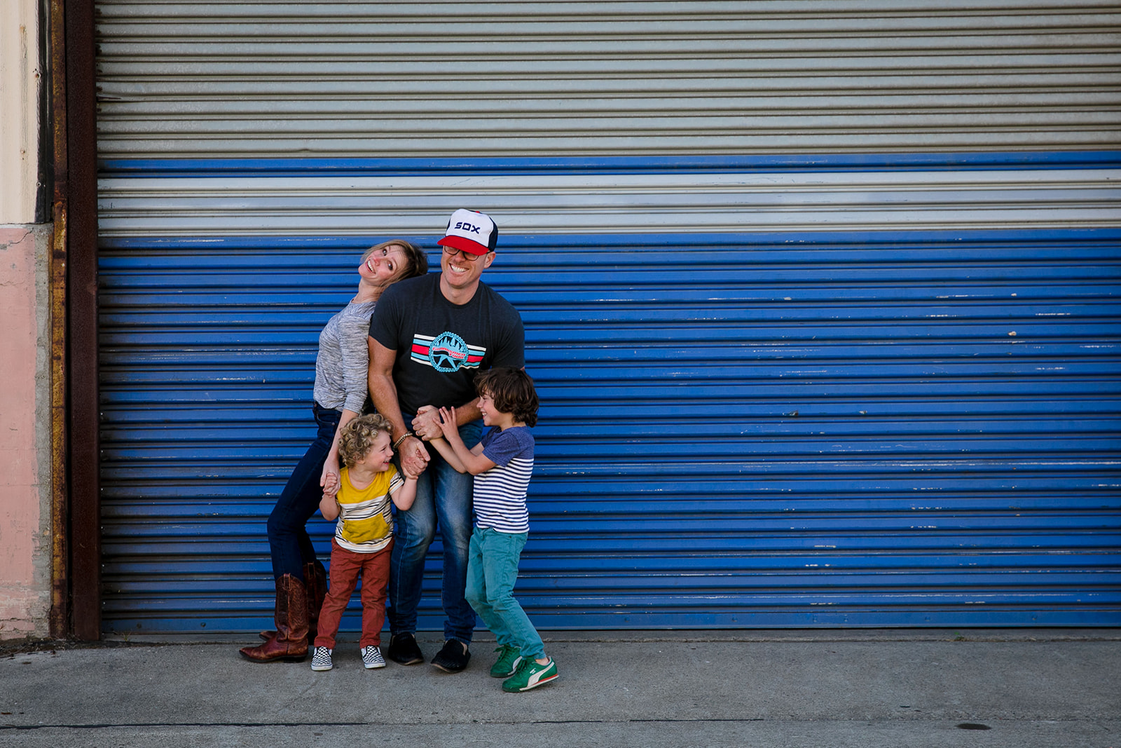 colorful family portrait in front of blue warehouse door