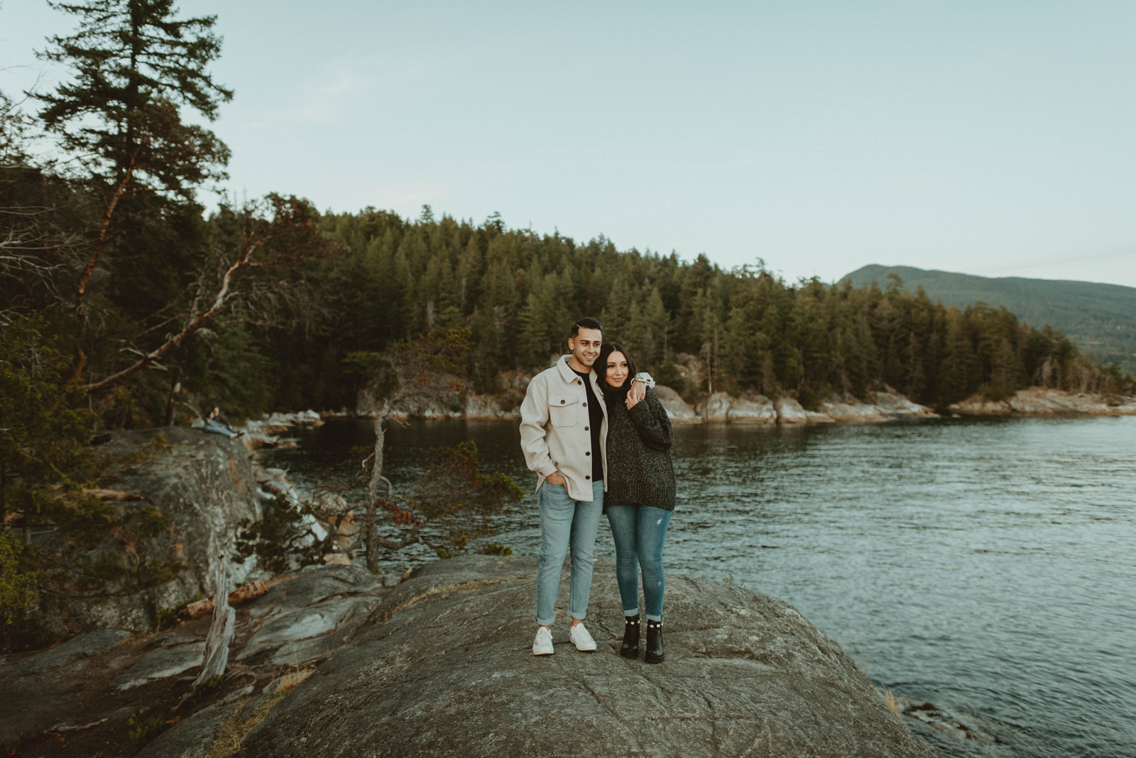 couple walking across cliff at Lighthouse Park in Vancouver