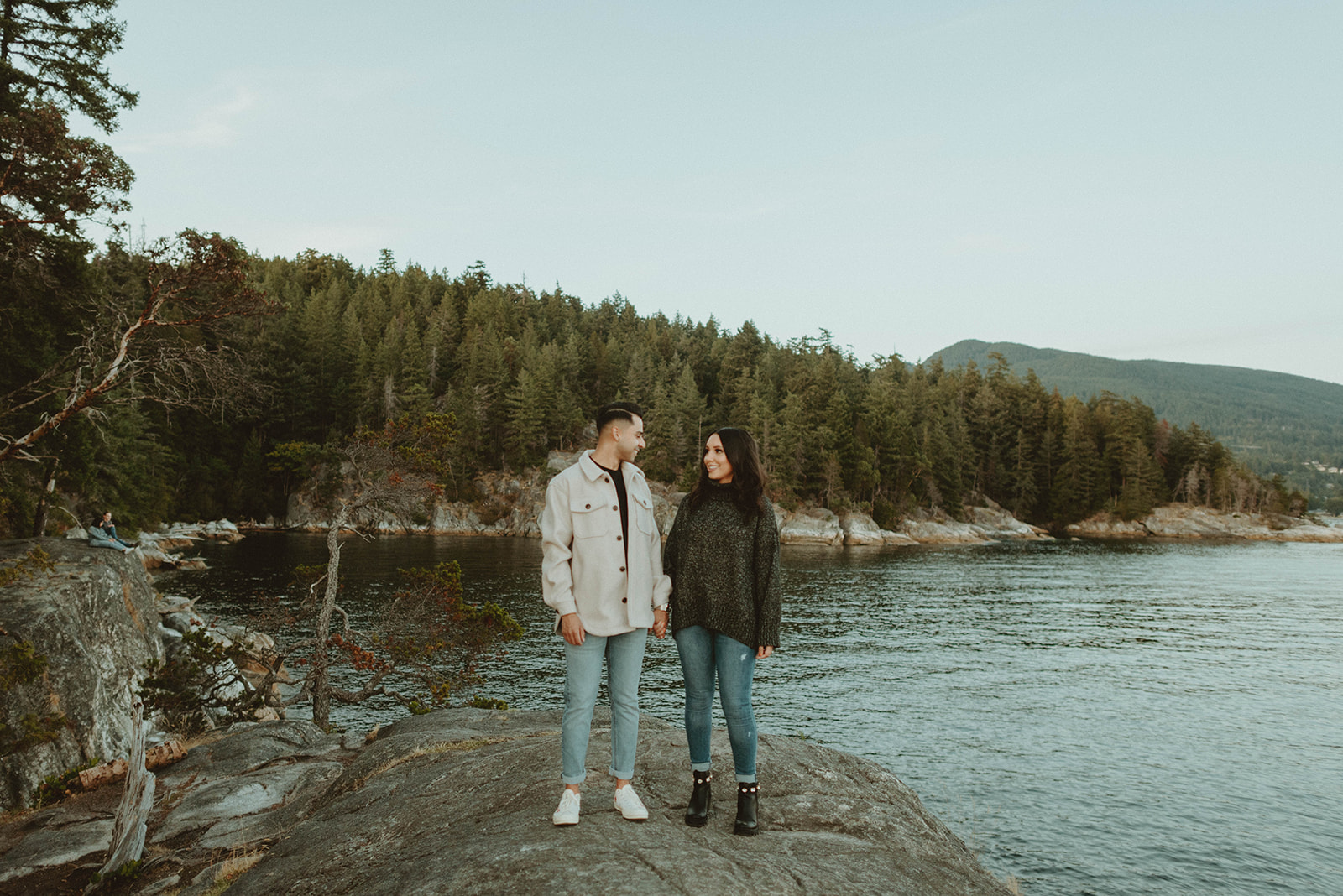 couple walking across cliff at Lighthouse Park in Vancouver