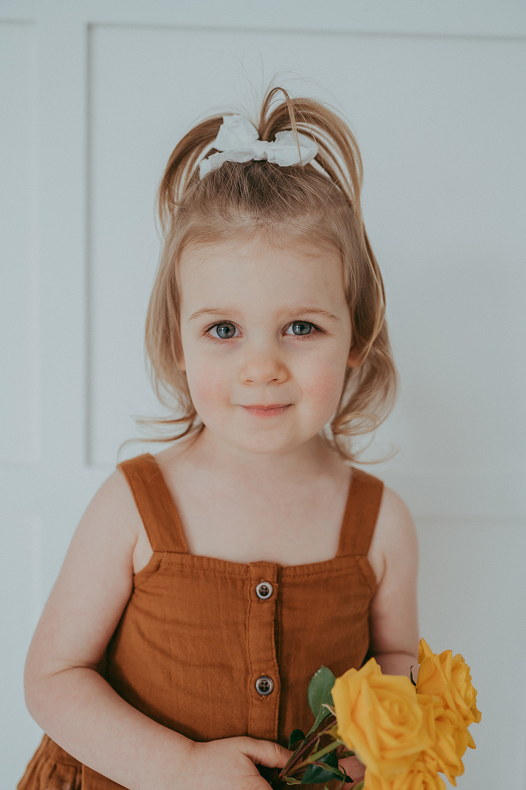 Little girl holding a flower in studio photo session