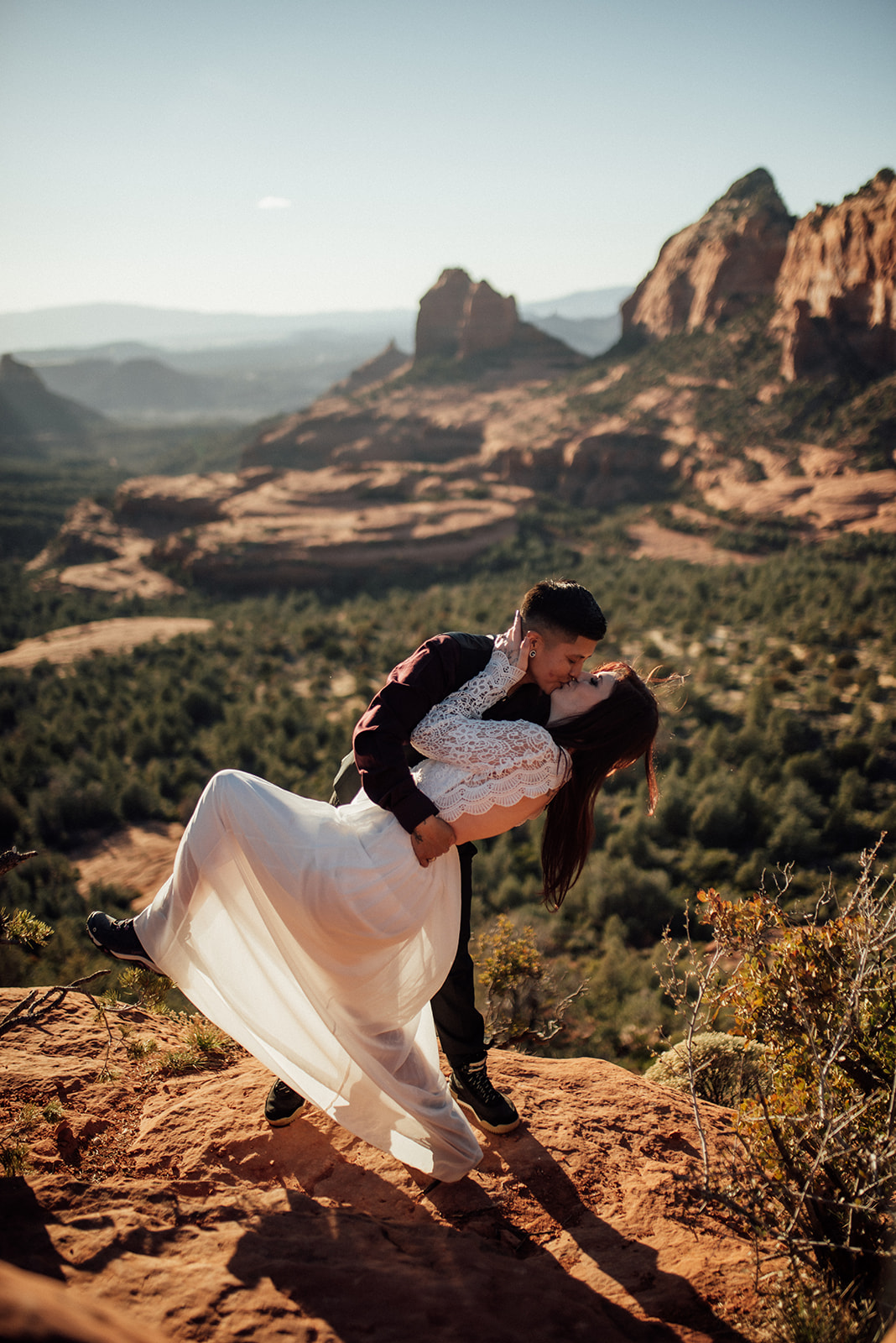lbtgqia+ couple kissing with Sedona red rock vista behind