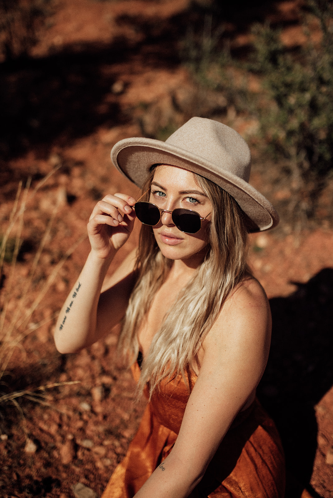 girl with sunglasses and hat in an orange dress in Sedona