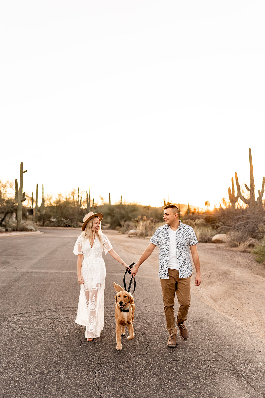 couple walking dog at desert engagement session in tucson arizona