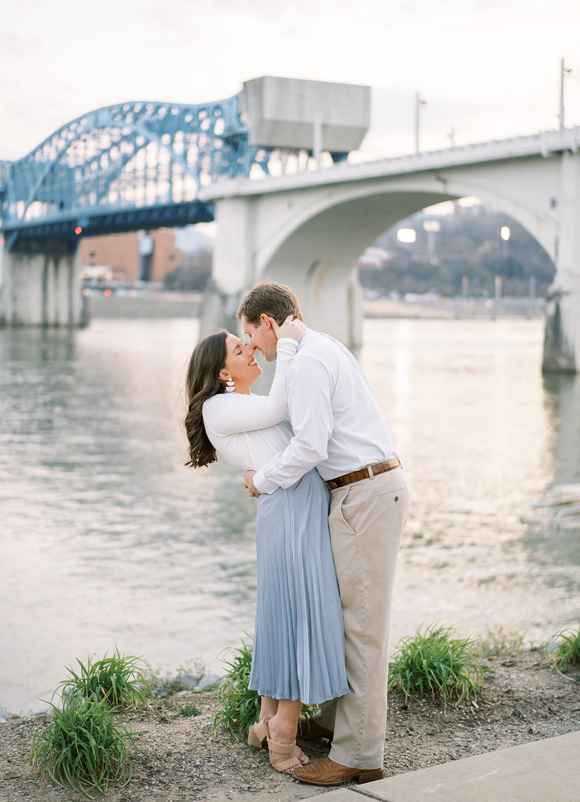 A couple kisses in front of the Market Street Bridge at Coolidge Park in Chattanooga, Tennessee