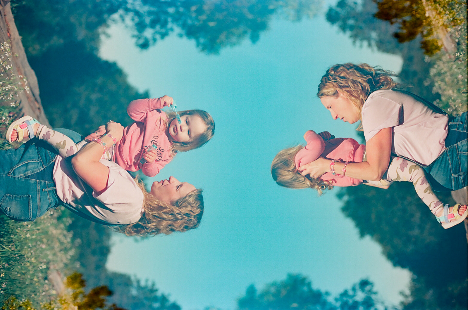 double exposure of pregnant mom holding toddler daughter on belly
