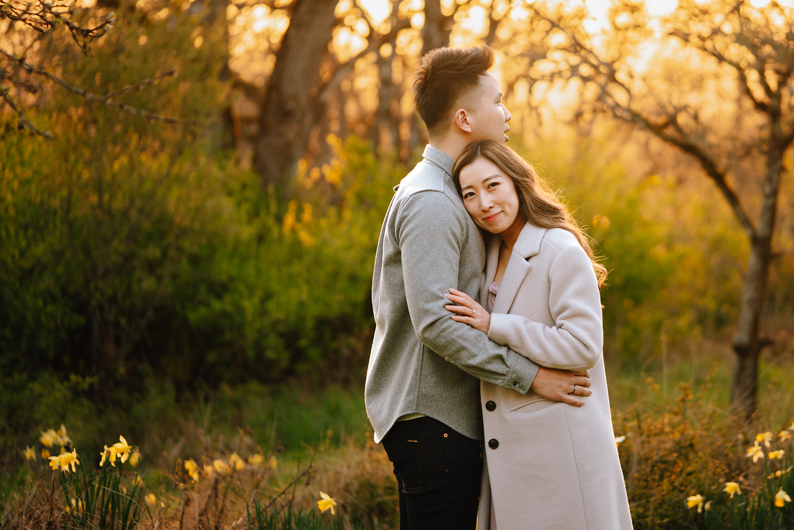 A couple surrounded by daffodils at golden hour for their engagement session in Victoria BC