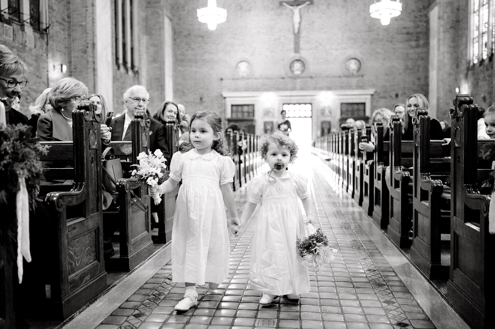 black and white photo cute flower girls holding hands at St. Patrick’s Cathedral Rittenhouse Square phiadellphia